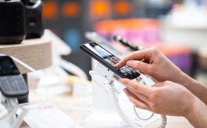 Persona usando un celular de una tienda de tecnología. (Getty Images)