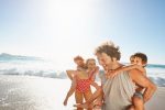 Familia disfrutando de sus vacaciones en la playa (Foto vía Getty Images)
