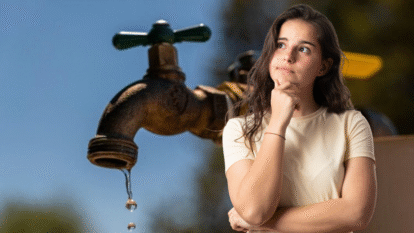 Grifo con agua cayendo y mujer pensativa |Getty Images